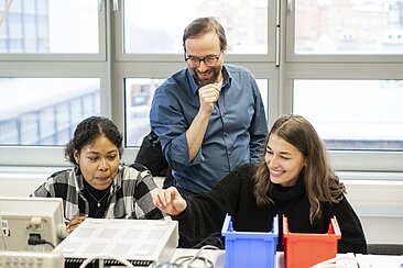 Christoph Schmitz betreut Studierende bei der Arbeit im Labor