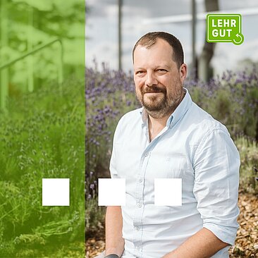 Mann mit hellem Hemd sitzt in einem Lavendelfeld vor einem modernen Gebäude. Links grüne Farbfläche mit den drei Quadraten vom Lehrenden-Service-Center. Rechts klare Darstellung der Person bei sonnigem Wetter und das LEHRGUT-Logo in der oberen rechten 