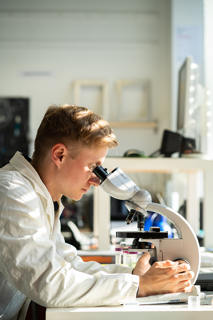 Johann Bauerfeind schaut durch ein Mikroskop