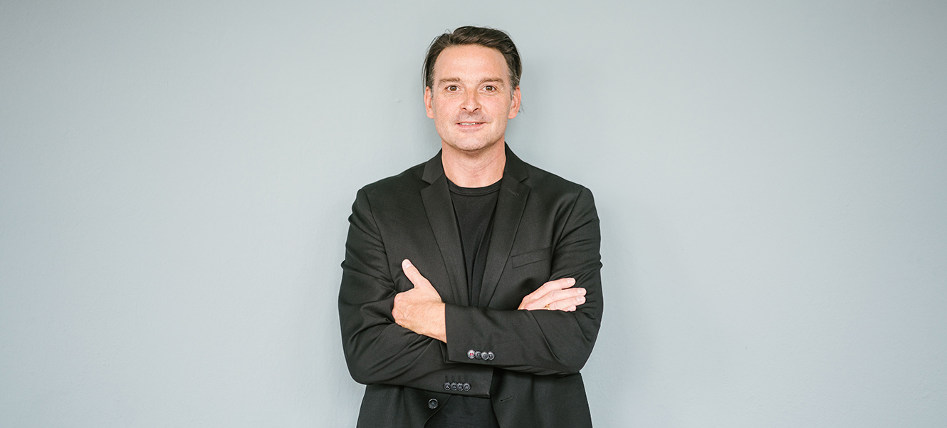 Kai Reinhardt vor grauem Hintergrund