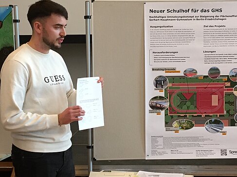 Student zeigt ein Blatt Papier