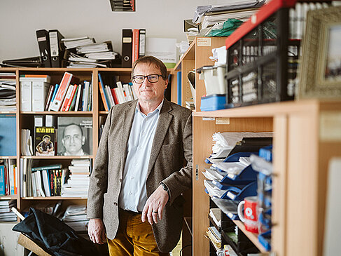 Oliver Rump vor gut gefüllten Regalen