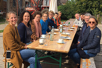 Menschgruppe sitzt am Tisch