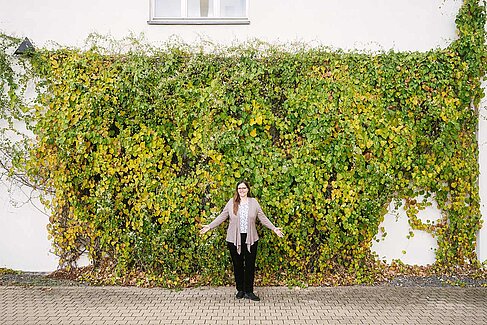 Dr. Susann Ullrich vor einer begrünten Gebäudewand