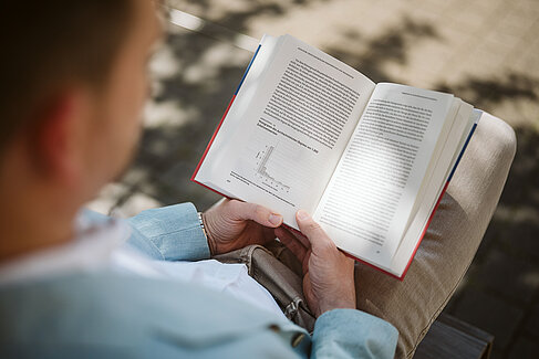 Jan Kocks liest in seinem aufgeschlagenen Buch