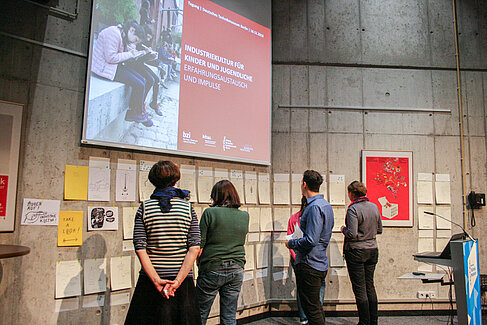 People looking at a large screen