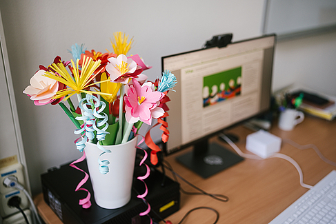 Farbenfroher Schreibtisch mit bunten Papierblumen