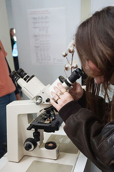Frau schaut durch ein Mikroskop