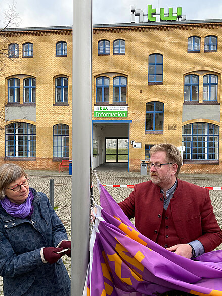 Die Frauenbeauftragte Dr. Sünne Andresen und Präsident Prof. Dr. Carsten Busch hissen die Aktionsfahne am Campus Wilhelminenhof © HTW Berlin/Anja Schuster