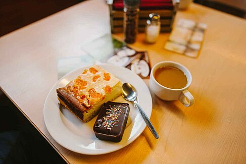 Kaffeetasse und Kuchen auf Teller 