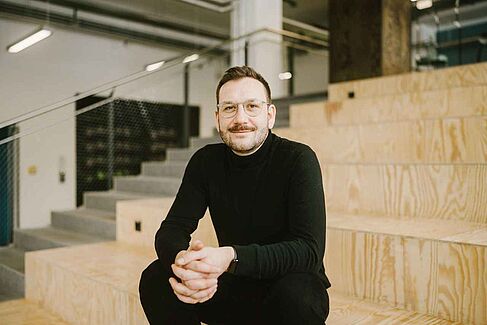 Matthias Sanner im Event-Room © HTW Berlin_Alexander Rentsch Matthias Sanner sitzt auf Treppenstufen