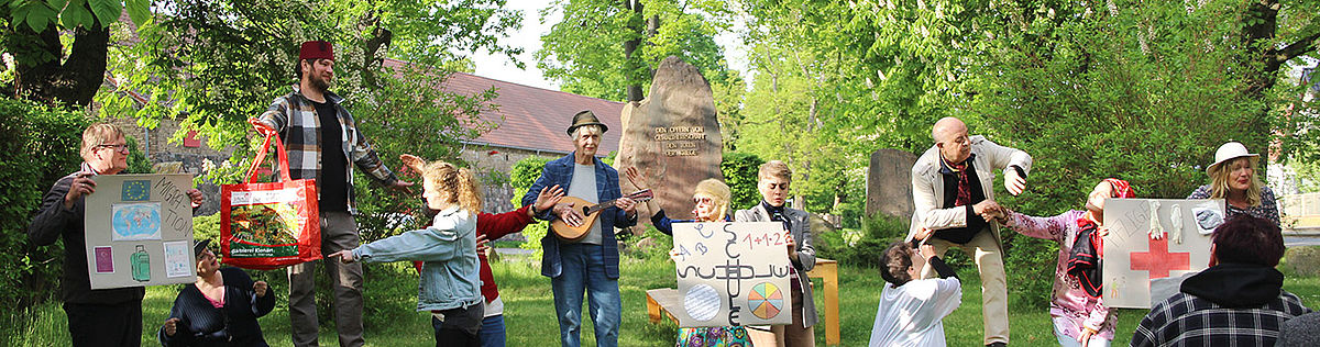 Menschen spielen Theater auf einer Wiese