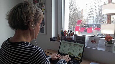 Eine Frau tippt in ihren Laptop