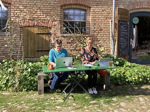 Zwei Frauen vor Laptops