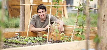 Student squatting in front of a raised bed