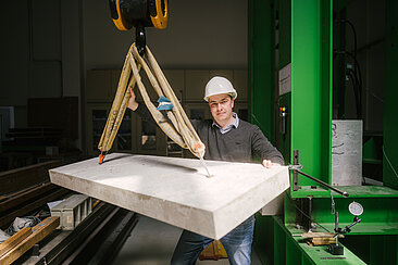 Mann mit Betonplatte am Seil 