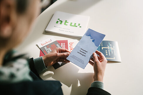 Ulrike Richter mit Infomaterial, darunter einem Flyer mit der Auftschrift "hinsehen, handeln, vorbeugen" in ihren Händen