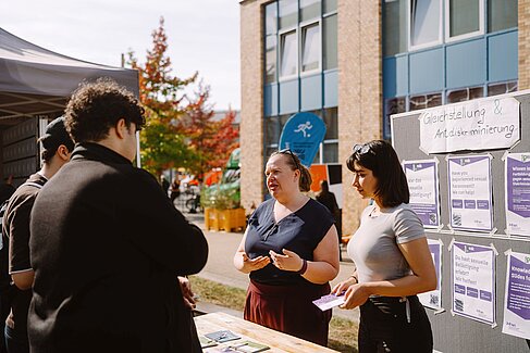 Zwei Mitarbeitende beraten Studierenden am Infostand © HTW Berlin/Alexander Rentsch