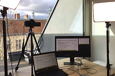 Zwei Laptops und eine Kamera mit Blick auf eine Terrasse