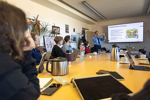 Menschen in einem Raum großem Bildschirm