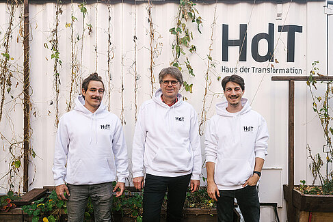 Drei Männer im weißen Hoody