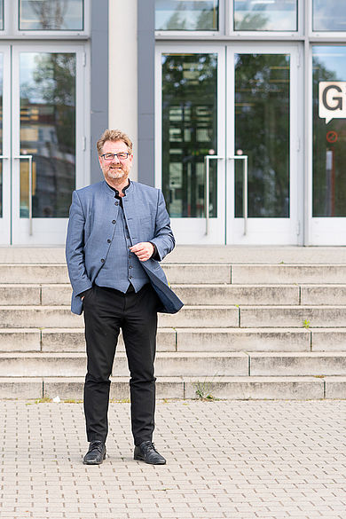 Carsten Busch steht vor der Treppe an der Mensa-Terrasse