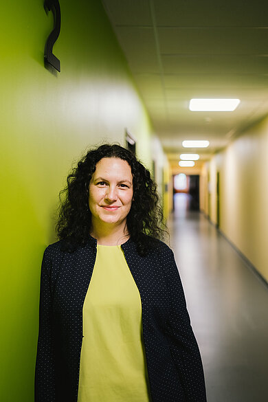 Dr. Lena Simon in einem gelben Flur