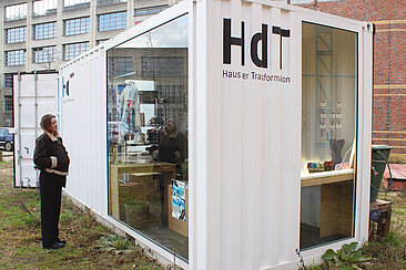 Frau steht vor Container