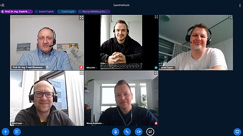Fünf Gesichter auf Bildschirmen bei einer Videokonferenz