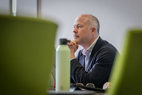 Der Vorsitzende Kristoff Ritlewski sitzt am Tisch und hört aufmerksam zu.