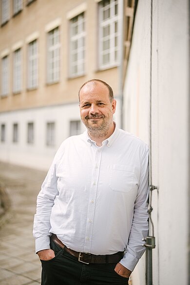 Martin Heckelmann lehnt an einer Gebäudefassade