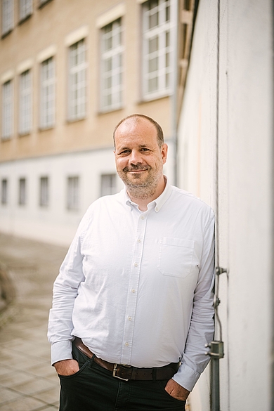 Martin Heckelmann lehnt an einer Gebäudefassade