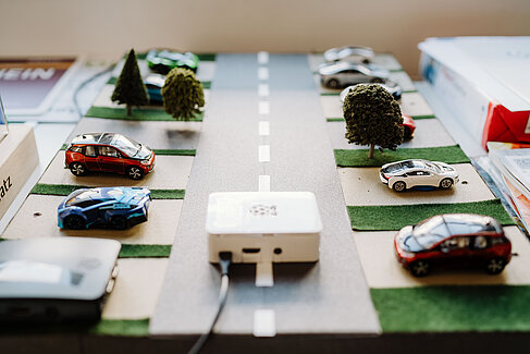 Ein Modell mit Elektroautos und Ladesäulen
