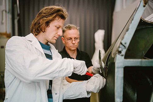 Zwei Männer bei der Arbeit am Flugzeug