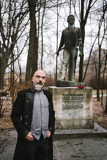 Prof. Dr. Dimitrios Zikos vor einem Personendankmal
