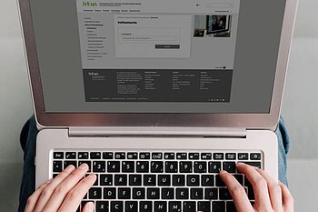 Hände auf Tastatur eines Laptops