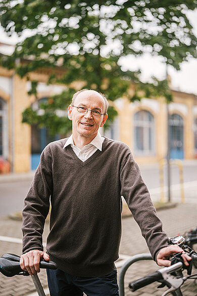 Mann steht am Fahrradständer