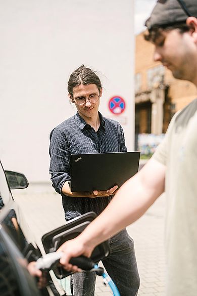 Joseph Bergner und Lucas Meissner beim Laden eines Elektrofahrzeugs