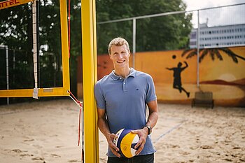 Pascal Hildebrandt mit Volleyball auf dem Beachvolleyballplatz auf dem Campus Treskowallee