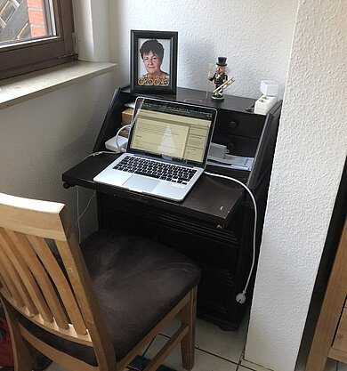 Stuhl an einem Tisch, darauf ein Laptop
