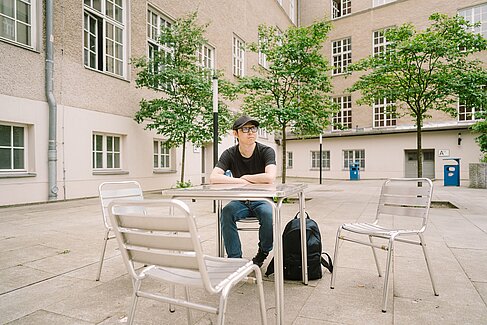 Niu Li sitzt an einem Tisch