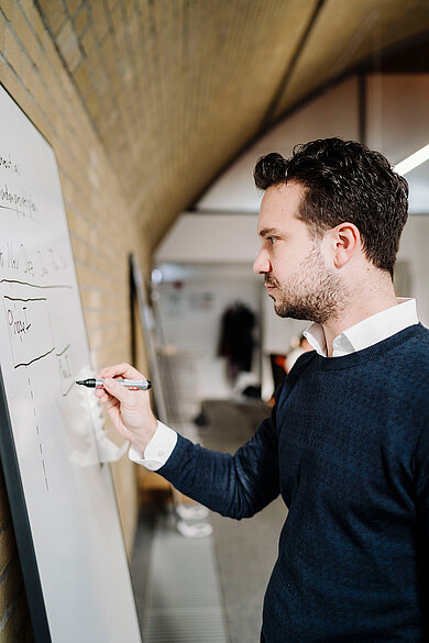 Gründer Tim Wegner schreibt etwas auf ein Whiteboard