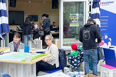 Menschen vor buntem Container