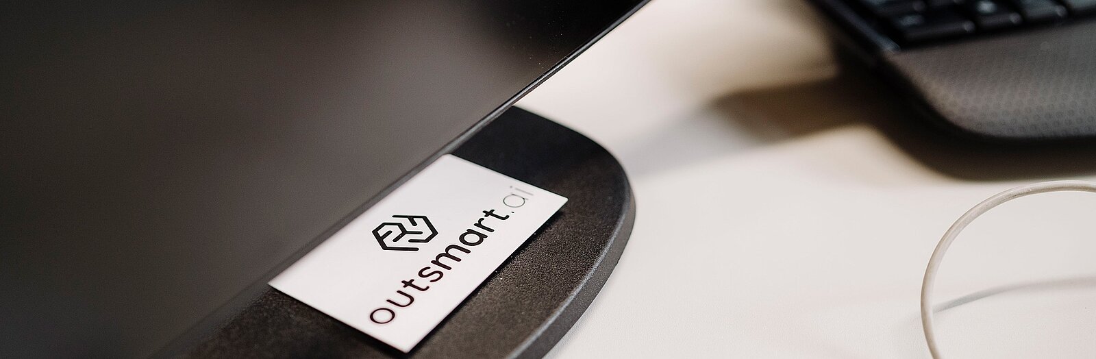 Das Logo von outsmart.ai auf einer Visitenkarte