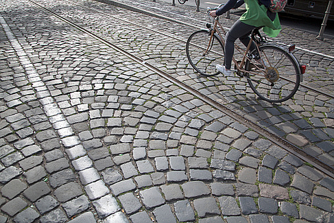 Radfahrerin fährt auf Kopfsteinpflaster