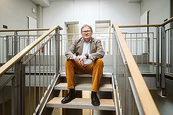 Oliver Rump sitzt auf der Treppe
