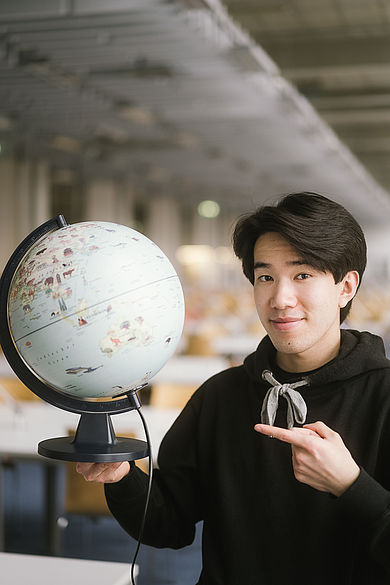 Student zeigt auf einen Globus © HTW Berlin/Alexander Rentsch