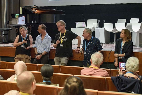 Vier Menschen vor einer Leinwand