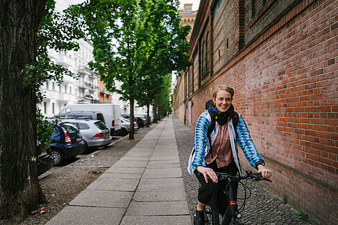 Laura Tihon auf dem Fahrrad, mit Airbag um den Hals