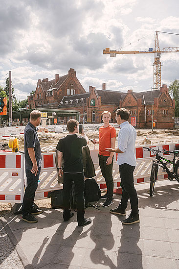 Vier Männer vor einer Baustelle